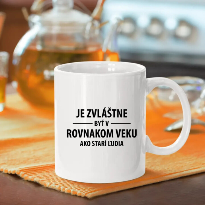 Je zvláštne byť v rovnakom veku ako starí ľudia - keramický hrnček s potlačou